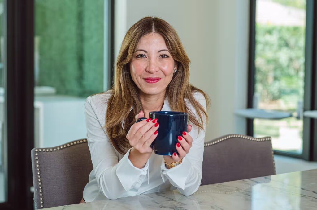 Woman holding blue mug at table
