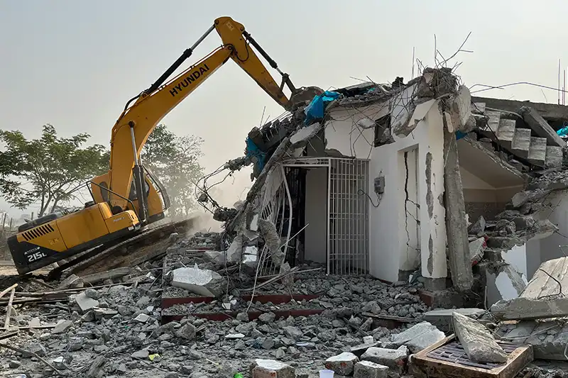 Excavator tearing down concrete building structureRetry