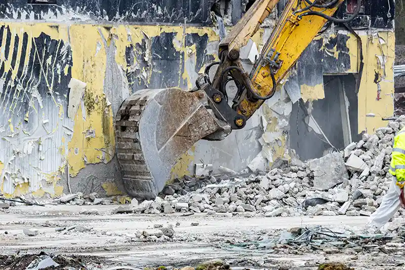 Excavator bucket smashing through yellow buildingRetry