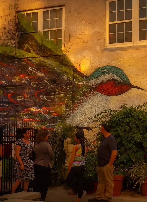 Group admiring large outdoor bird artwork