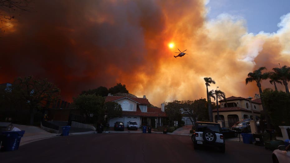 Helicopter flying over wildfire near homesRetry