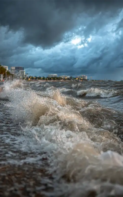 Powerful storm surge waves crashing ashore under dark threatening Florida skies
