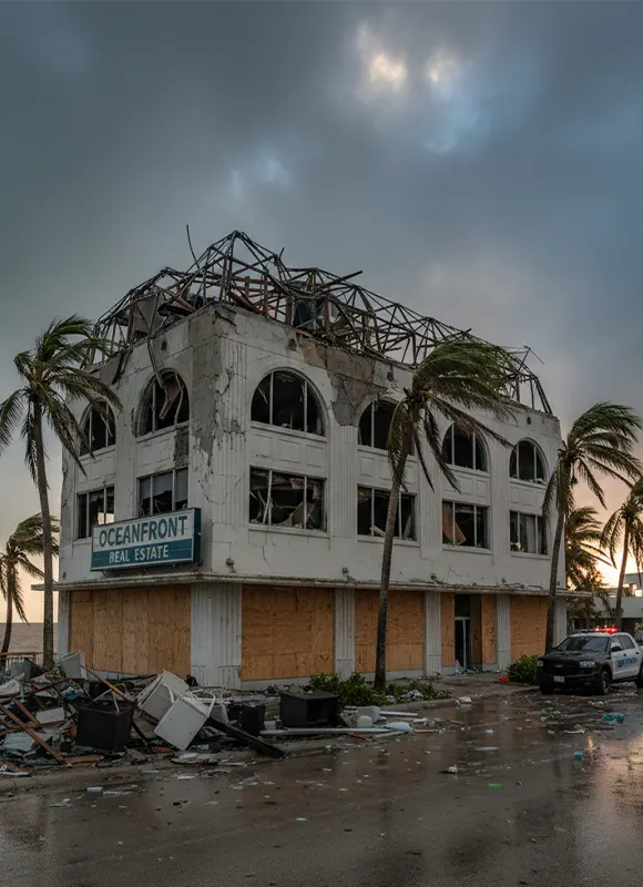 Hurricane-destroyed Oceanfront Real Estate building with debris and palm trees