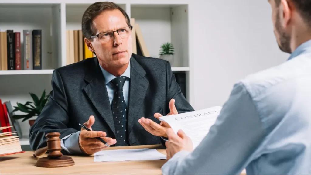 Lawyer reviewing contract with client at office desk